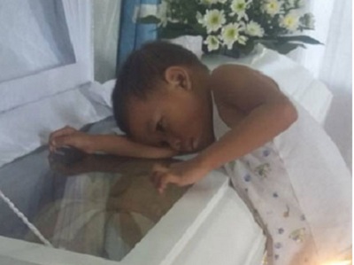 Nhói lòng hình ảnh bé trai 5 tuổi ngủ bên quan tài mẹ